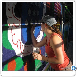 Mural artist Elisabeth Gambino painting stars with silver paint!
